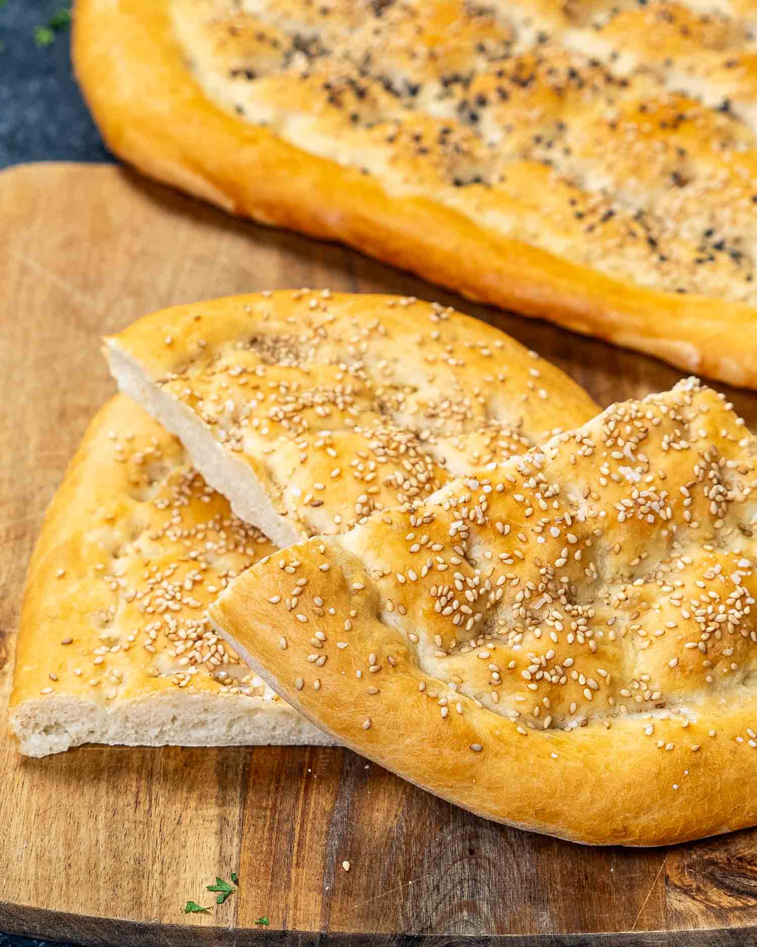 a freshly bread turkish bread on a cutting board.
