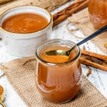 a tulip jar with applesauce in it made in the instant pot and a spoon inside the jar.