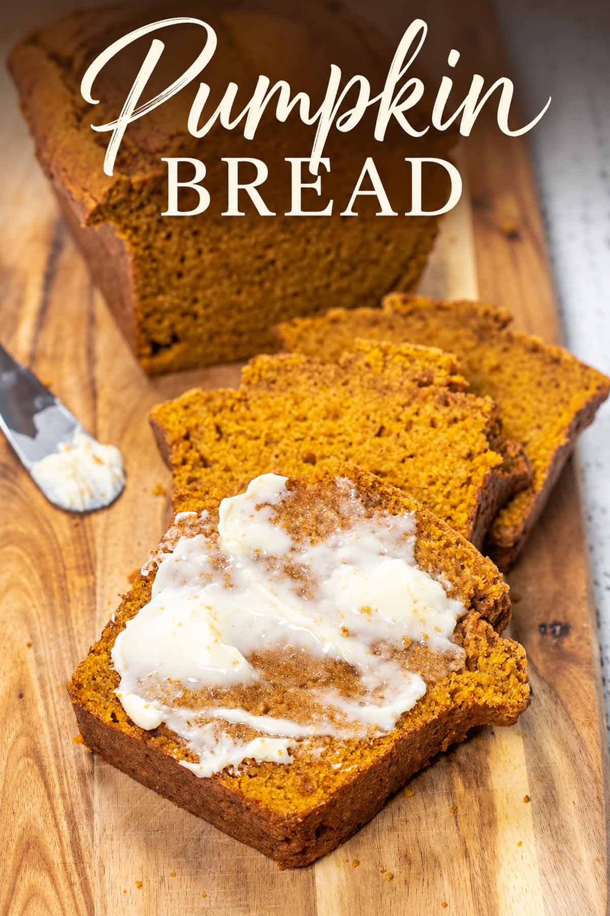 Sliced pumpkin bread on a wooden board with a buttered slice in front and elegant Pumpkin Bread text above.