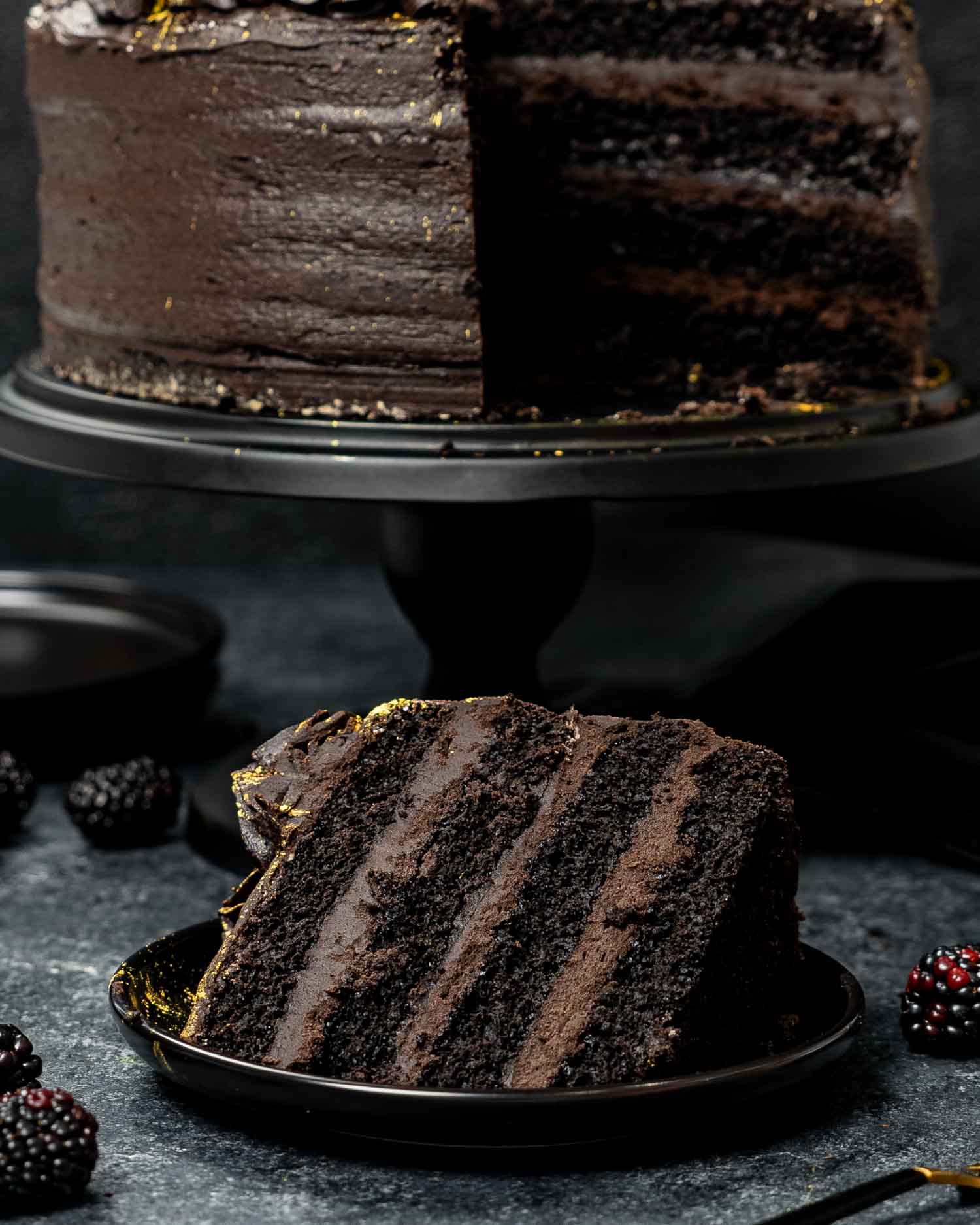 a slice of black velvet cake on a black plate.