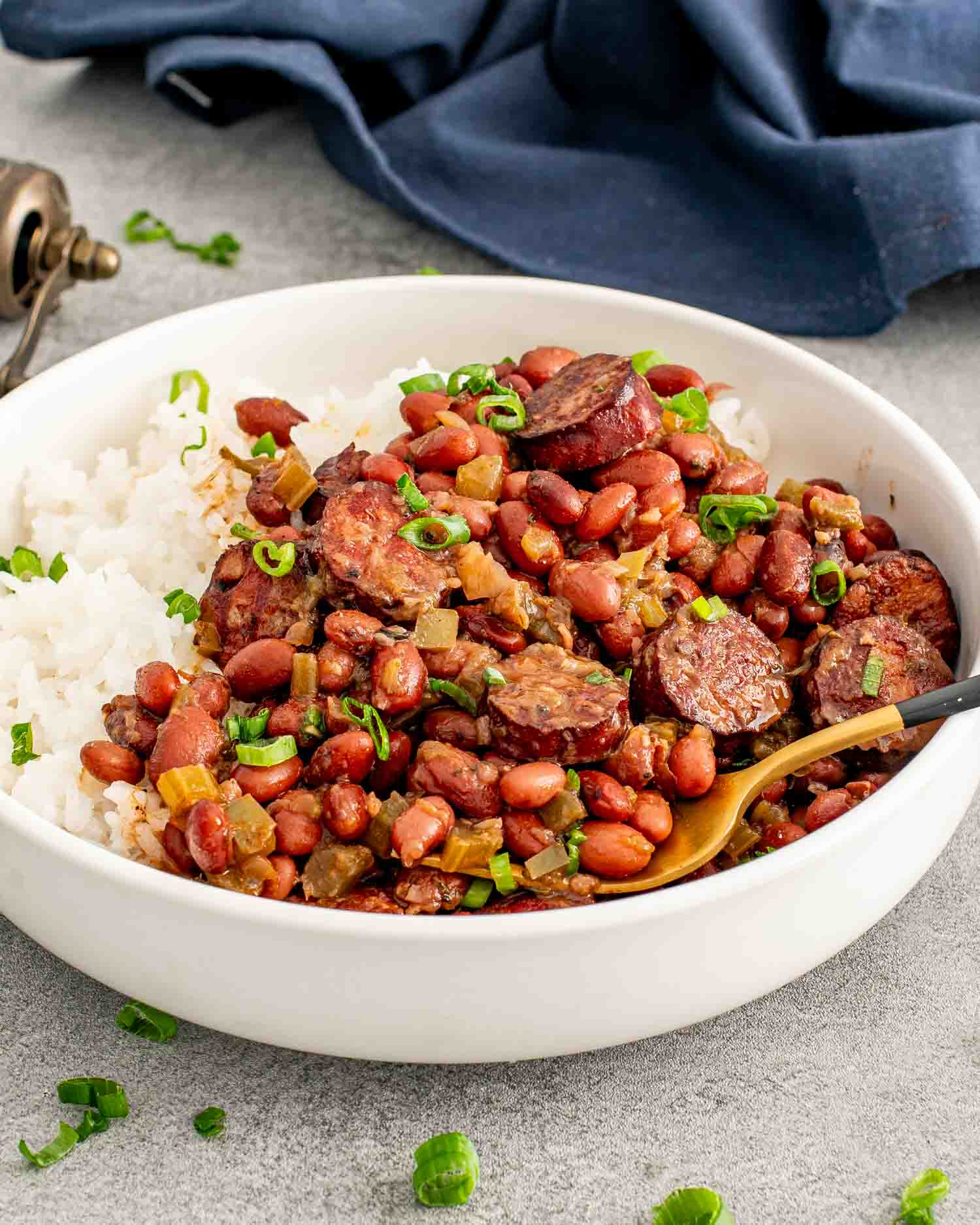 red beans and rice in a white bowl garnished with green onions.