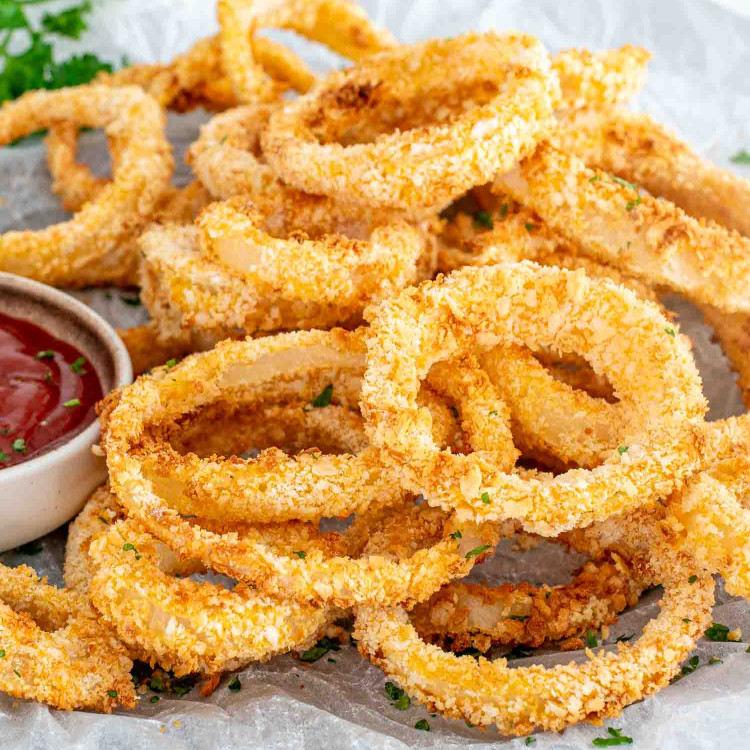 freshly made onion rings in the air fryer with ketchup.