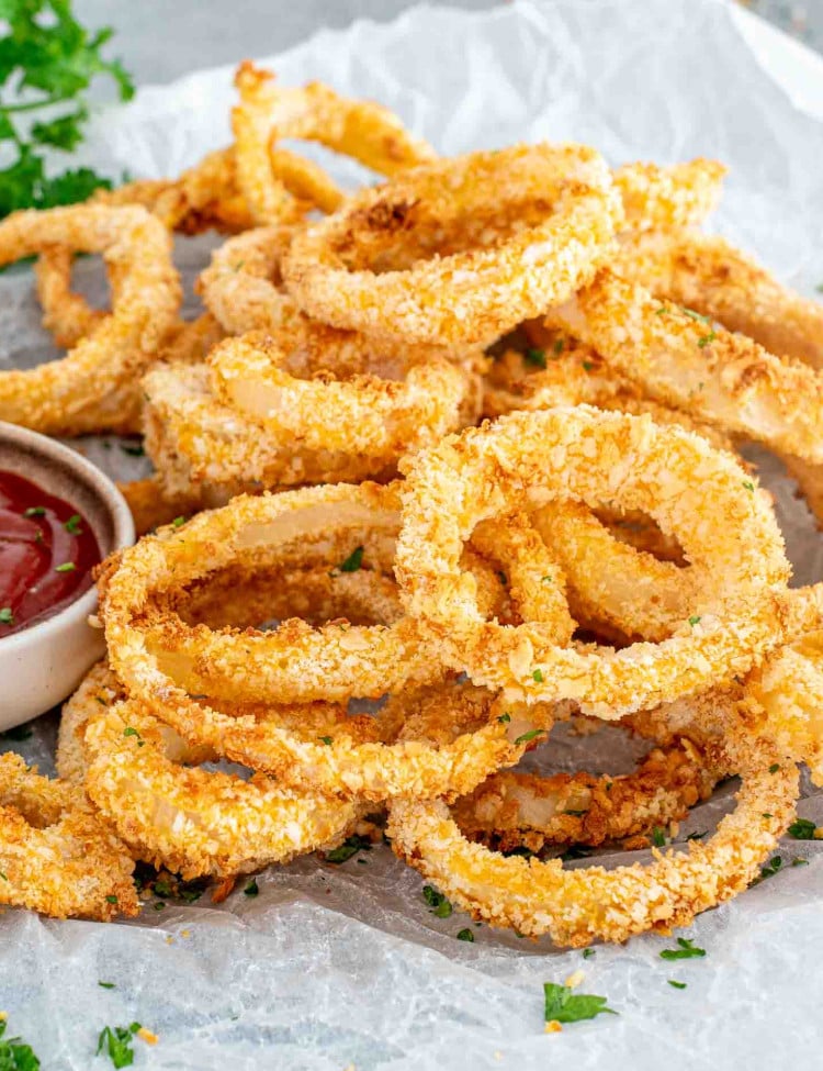 freshly made onion rings in the air fryer with ketchup.