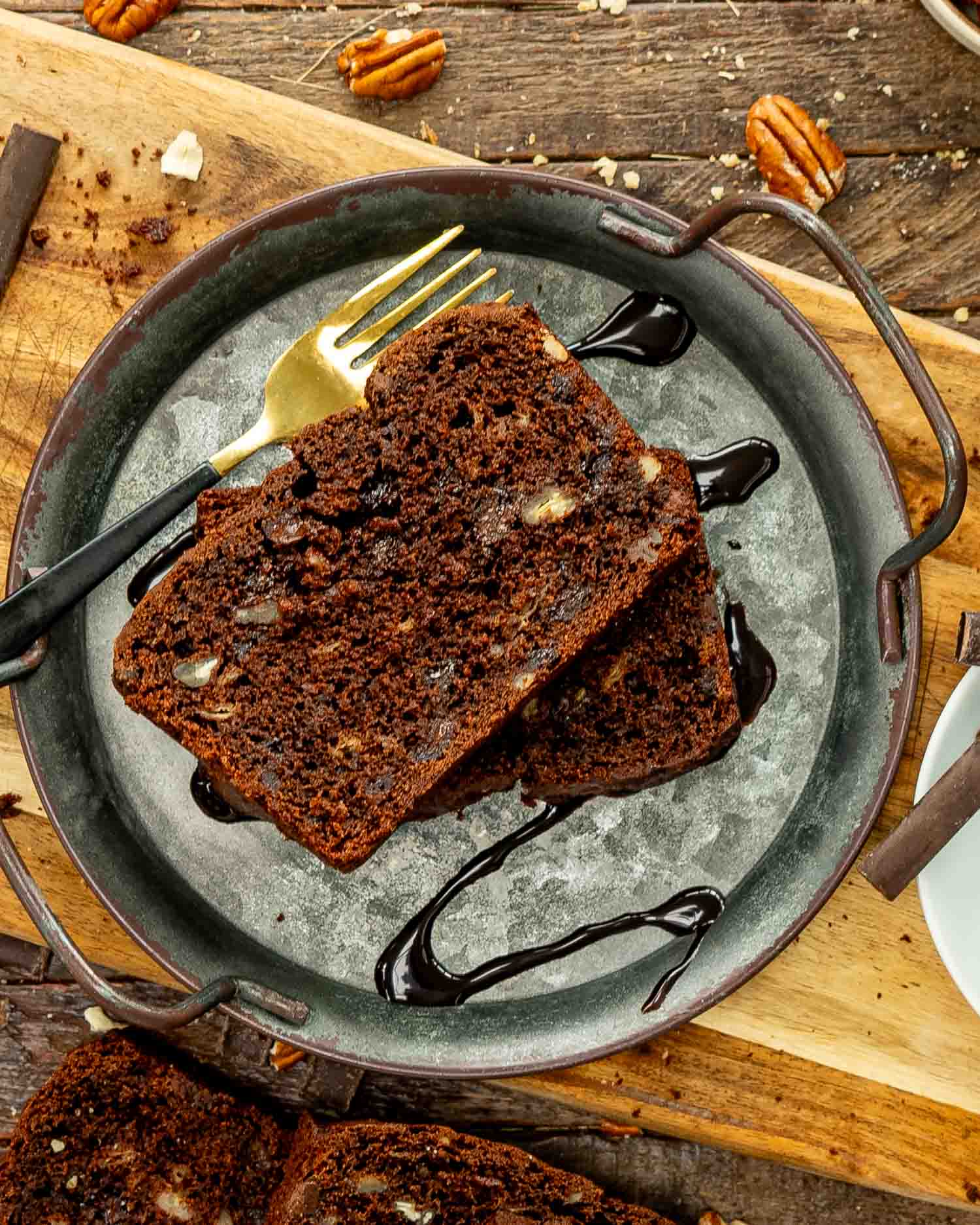two slices of chocolate banana bread on a metal plate.