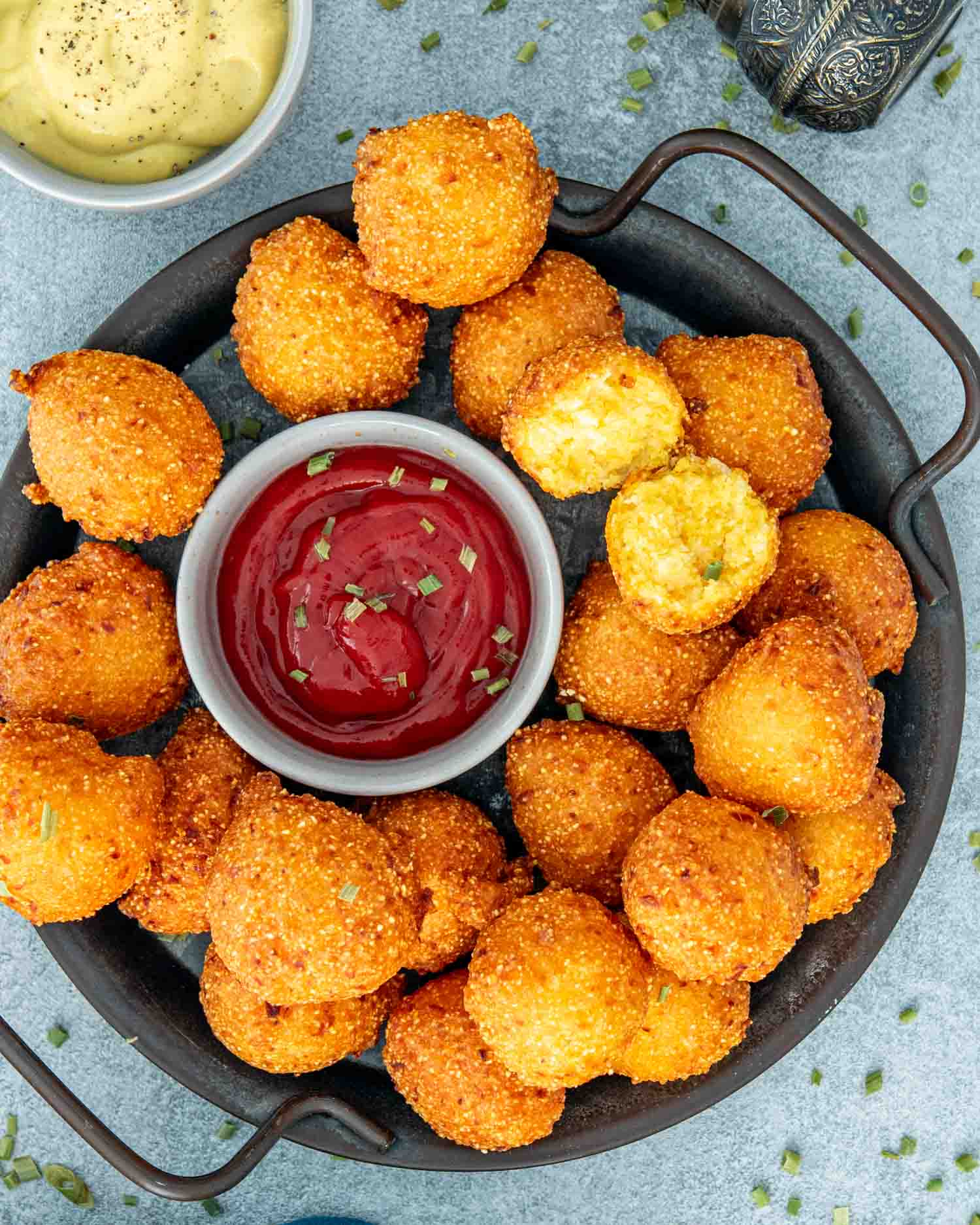 hush puppies on a plate with a little bowl with ketchup.