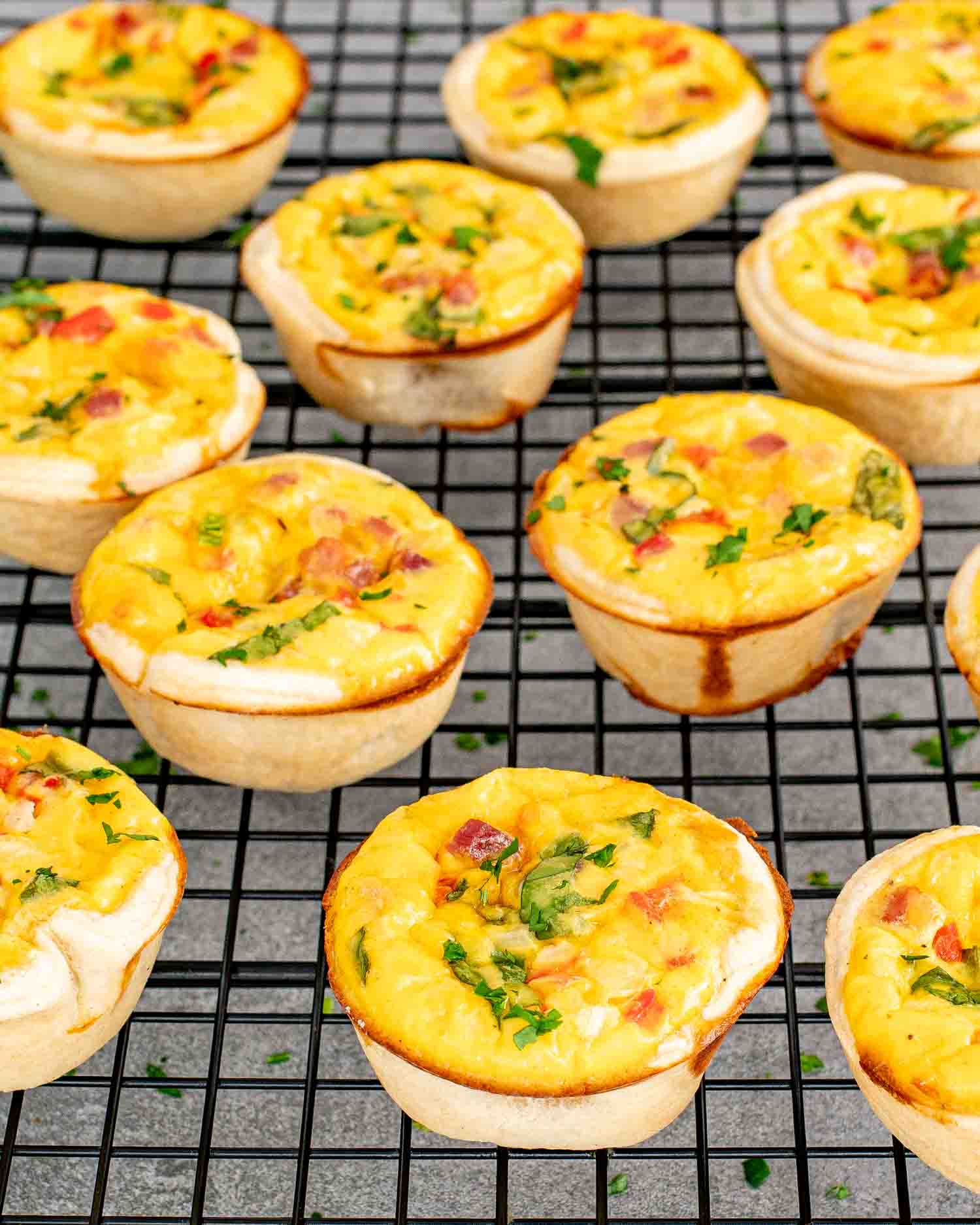 freshly baked mini quiches cooling off on a wire rack.