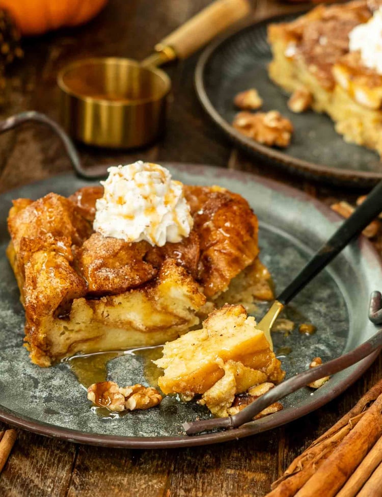 a slice of bread pudding with a dollop of whipped cream on a plate.