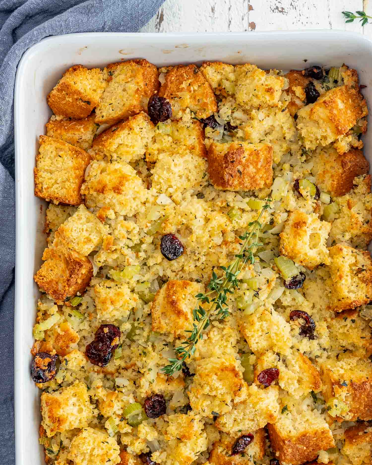 freshly baked cornbread stuffing in a white casserole dish.