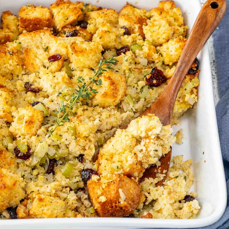 freshly baked cornbread stuffing in a white casserole dish.