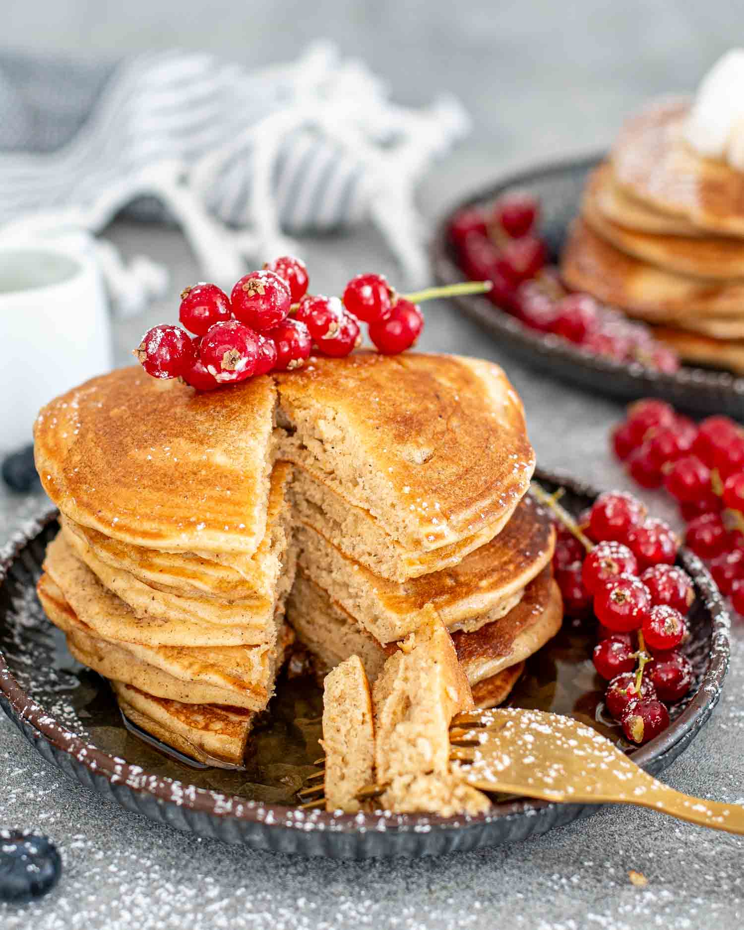 a stack of eggnog pancakes dusted with powdered sugar.