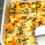 freshly baked strata cut into pieces in a white casserole dish.