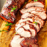 2 char siu pork tenderloins on a cutting board, one cut up in slices.