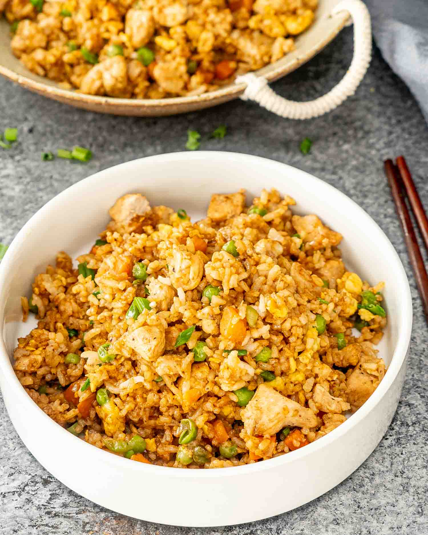 a serving of chicken fried rice in a white bowl.