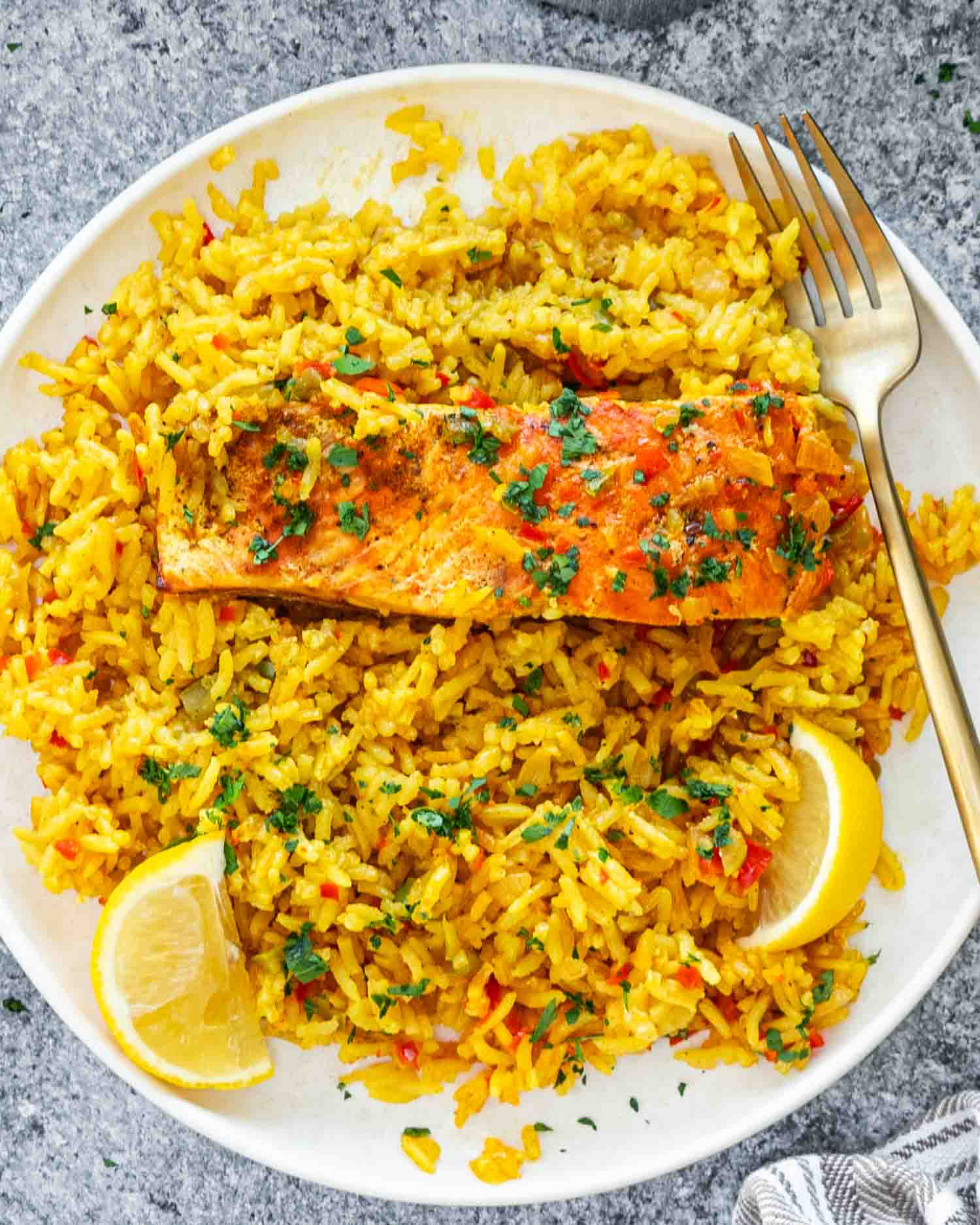 a serving of one pot salmon and rice on a white plate.
