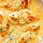 Golden Chicken Diane with mushrooms in a creamy sauce, sprinkled with parsley in a skillet.