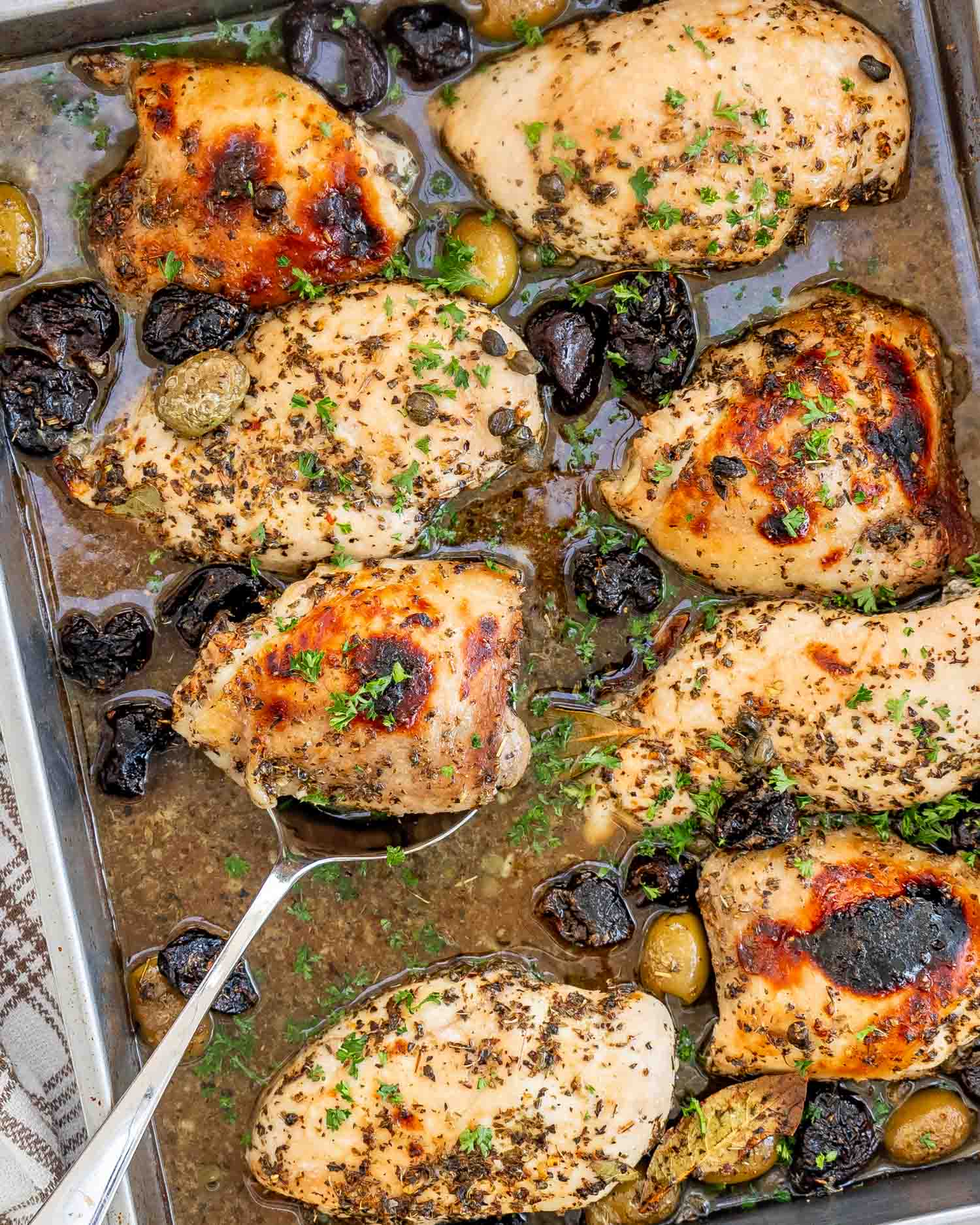 chicken marbella in a baking dish fresh out of the oven.
