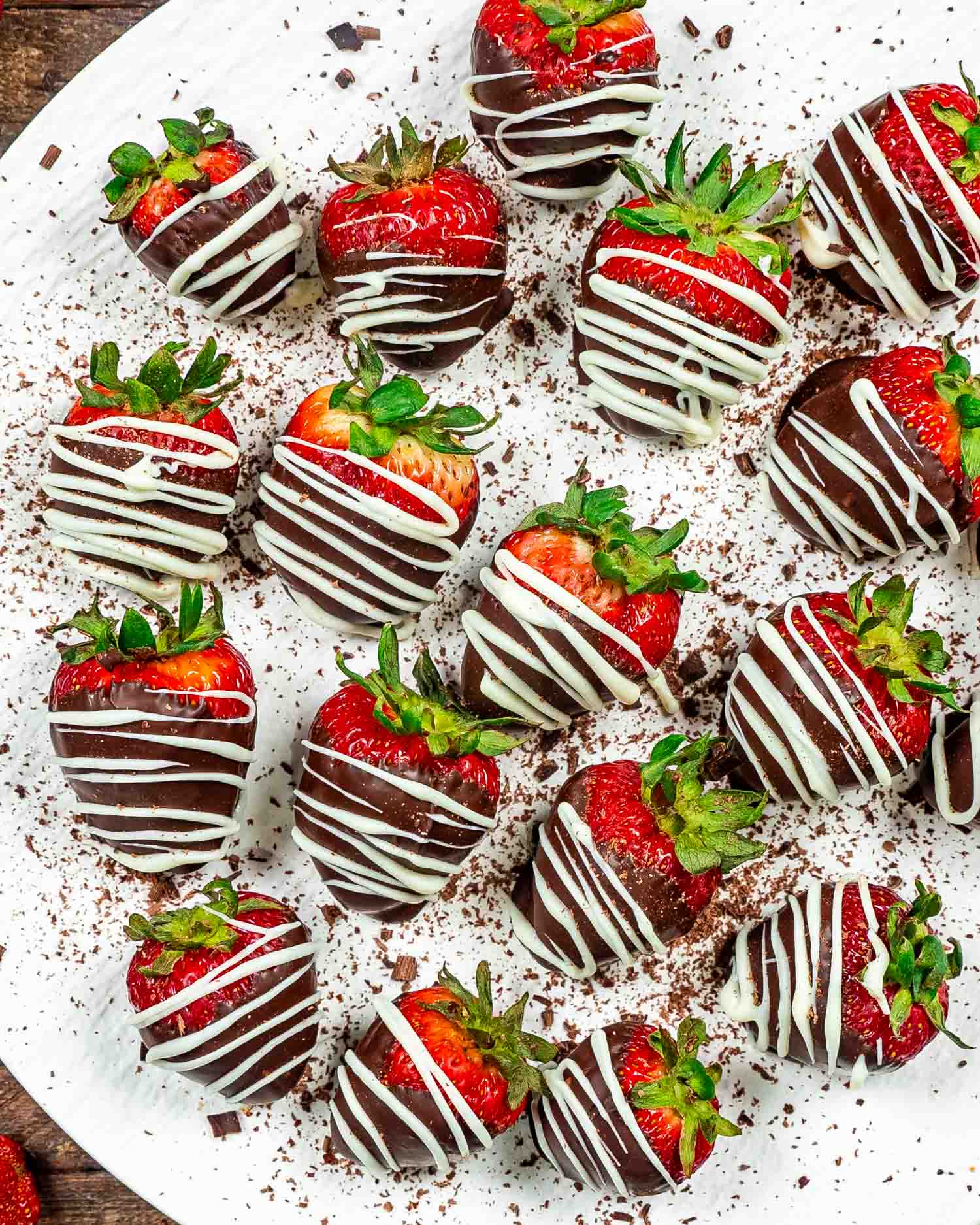 A plate of chocolate-covered strawberries with white chocolate drizzle, ready for a sweet Valentine's treat.