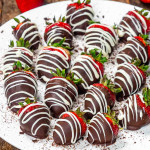 A plate of chocolate-covered strawberries with white chocolate drizzle, ready for a sweet Valentine's treat.