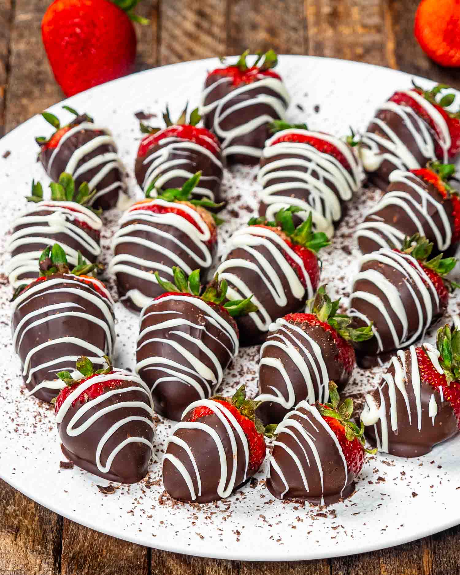 A plate of chocolate-covered strawberries with white chocolate drizzle, ready for a sweet Valentine's treat.