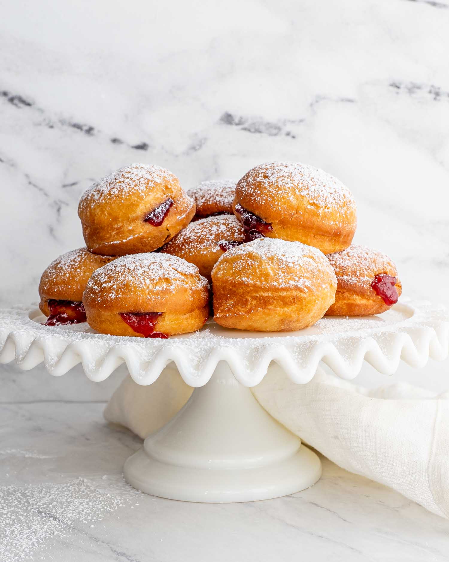 a cake platter filled with cherry jelly donuts.