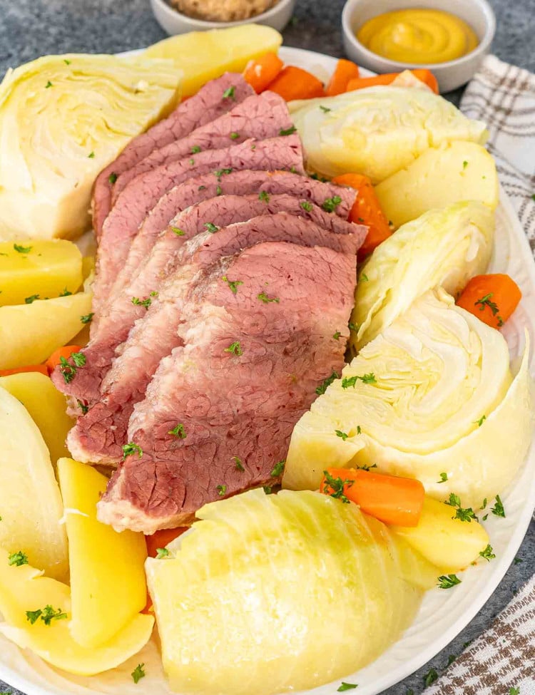 a platter with corned beef and cabbage and potatoes and carrots.