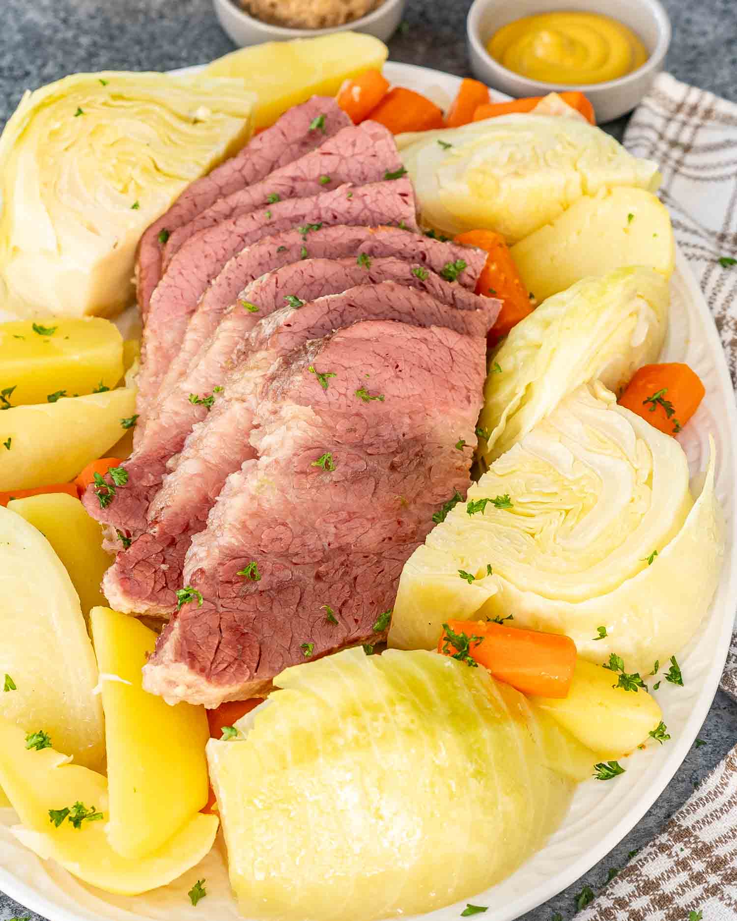 a platter with corned beef and cabbage and potatoes and carrots.