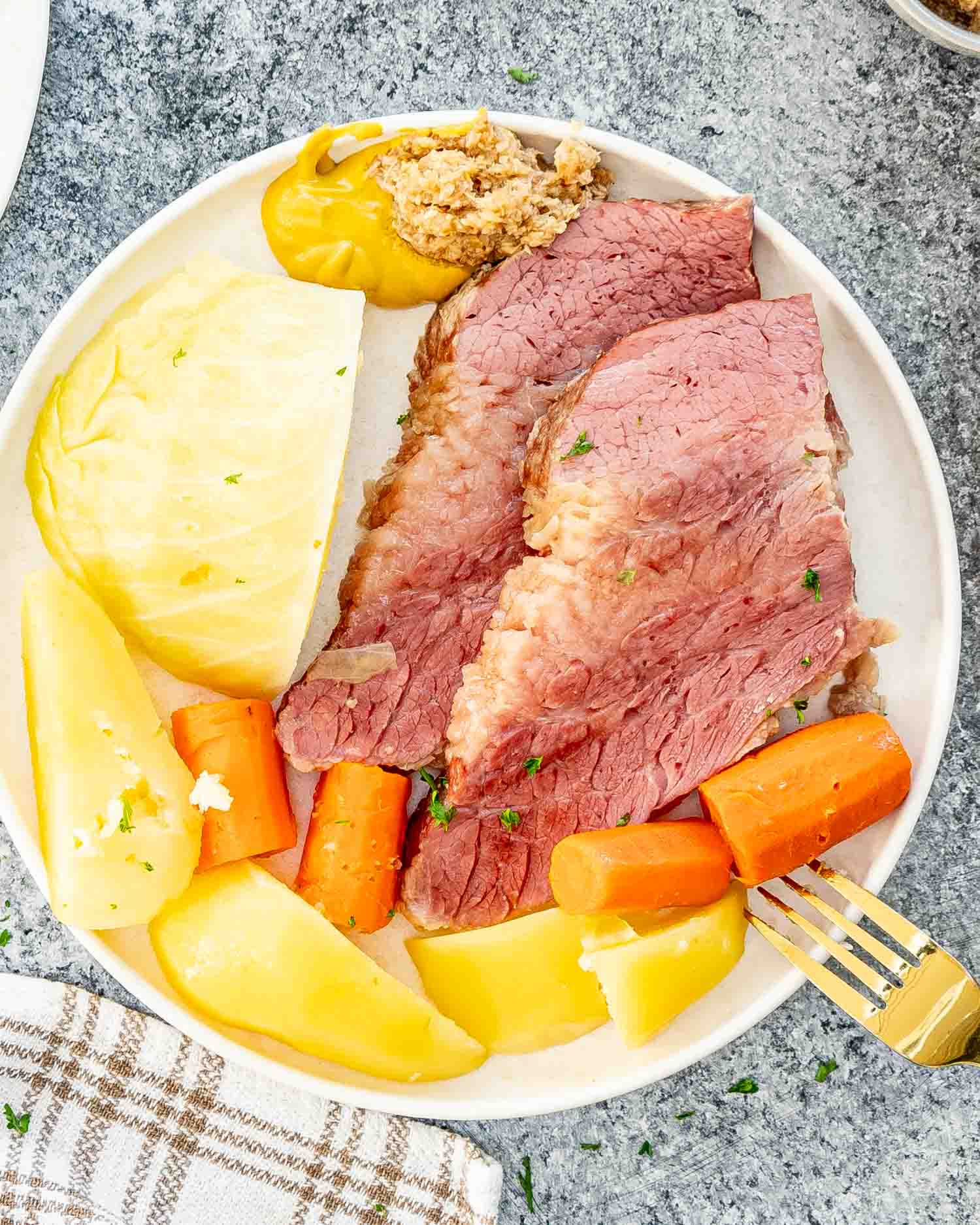 a serving of corned beef and cabbage on a white plate.