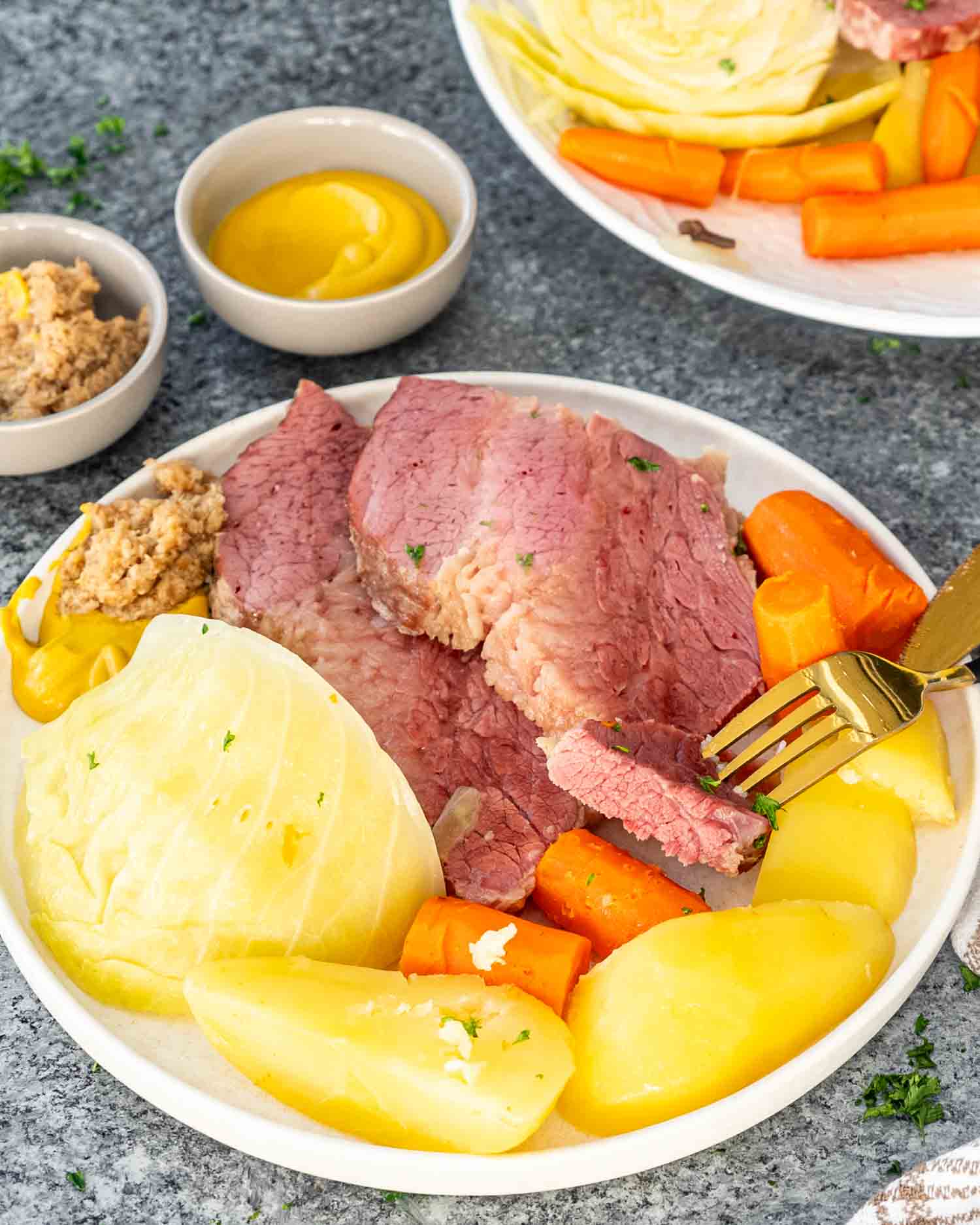 a serving of corned beef and cabbage on a white plate.