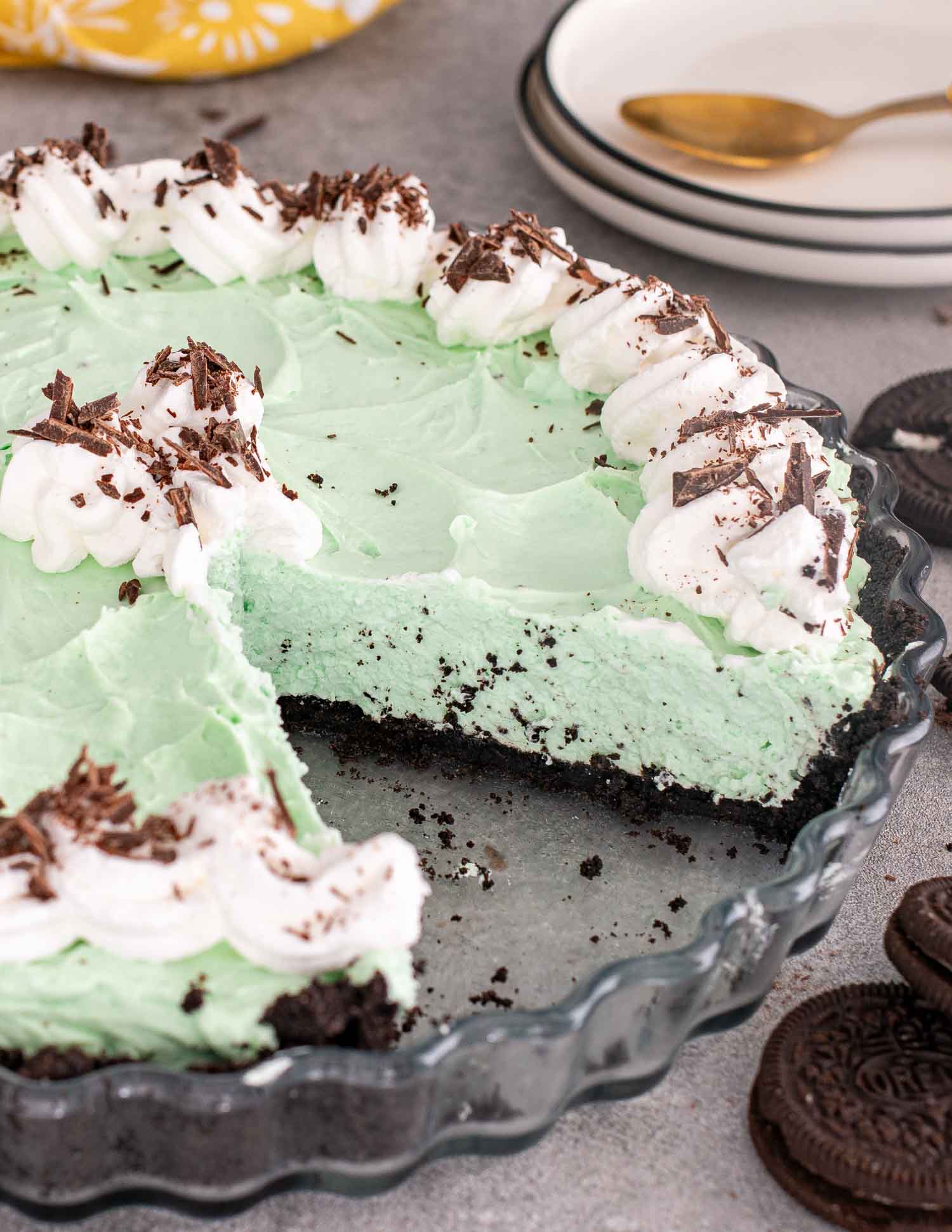 a grasshopper pie in a tart shell topped with whipped cream and oreo cookie crumble.