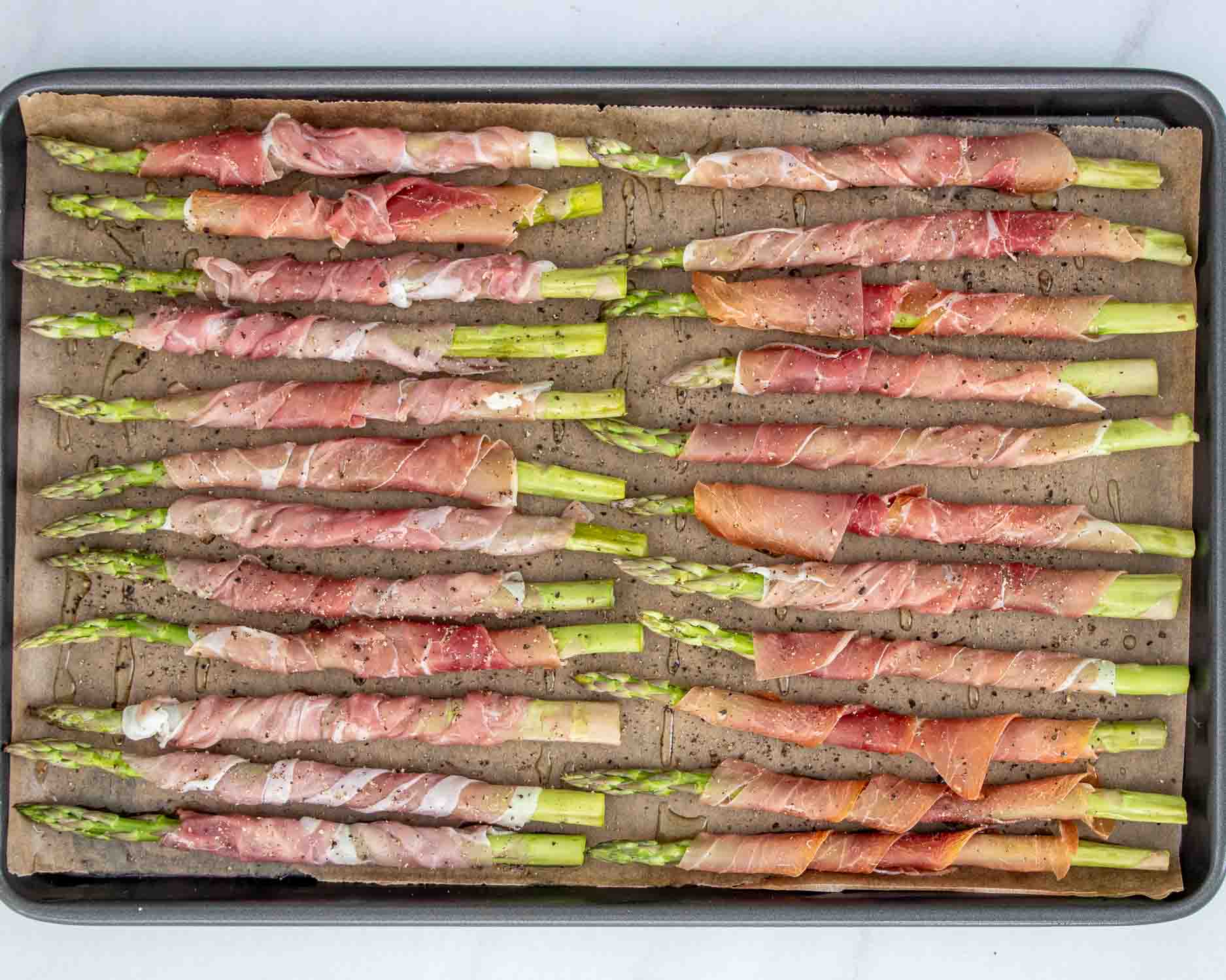 process shots showing how to make prosciutto wrapped asparagus.