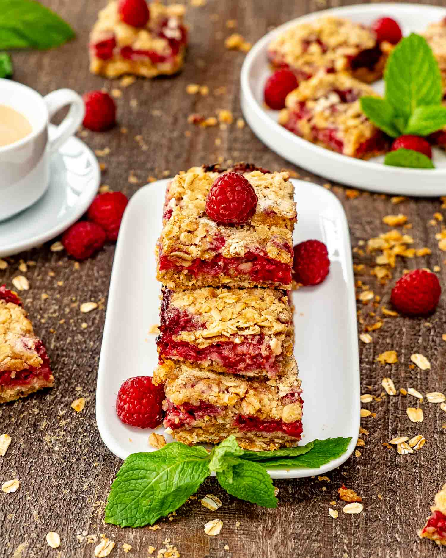 a stack of raspberry oatmeal crumble bars on a white plate.