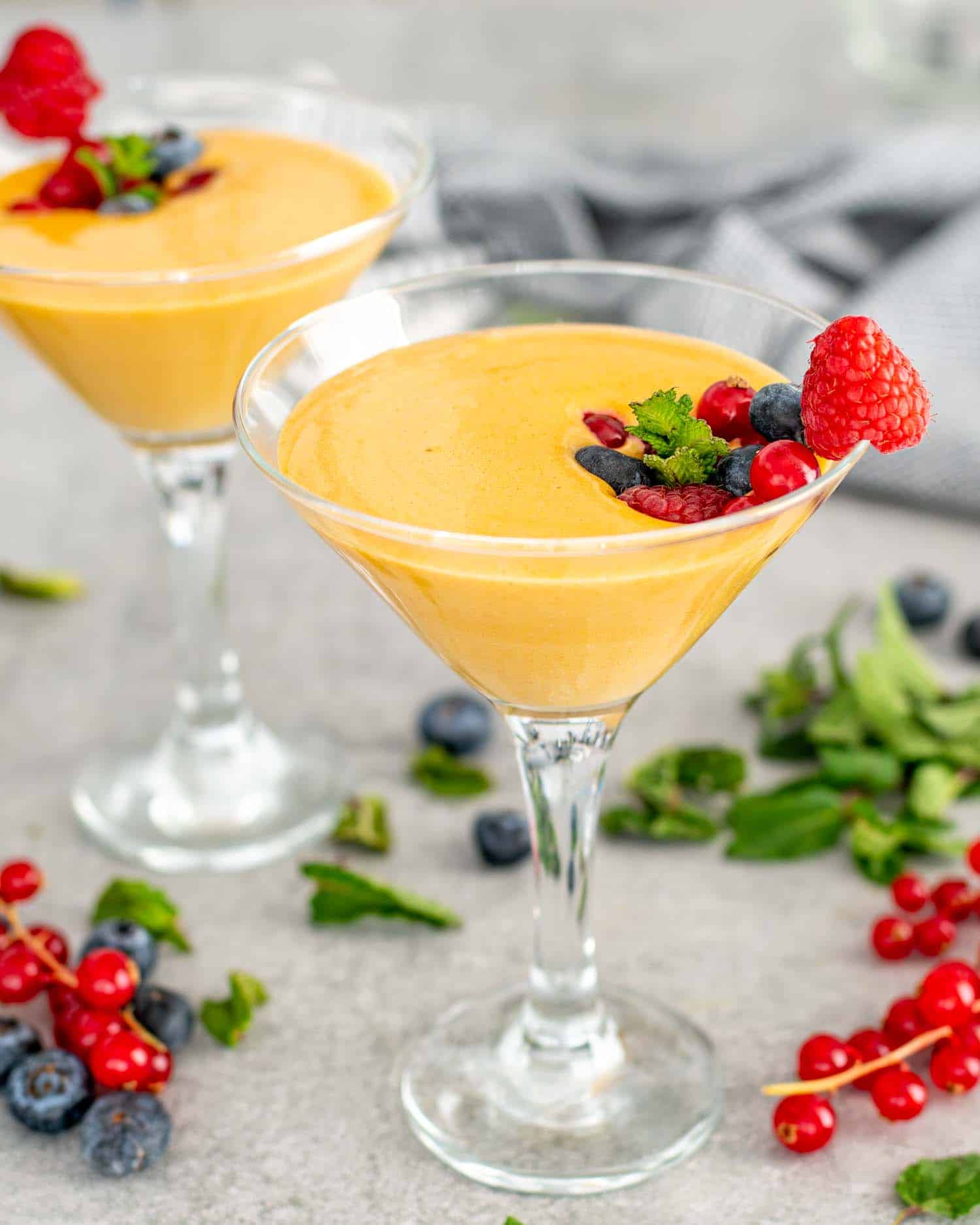 zabaglione in 2 glasses topped with berries.