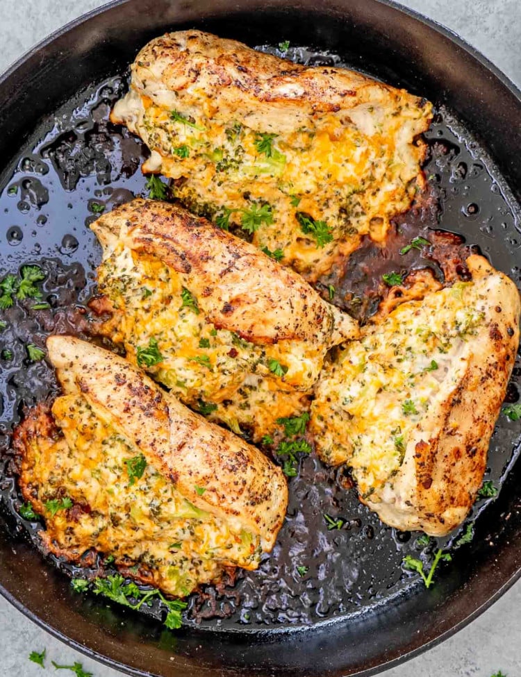 broccoli and cheddar stuffed chicken breast in a cast iron skillet.