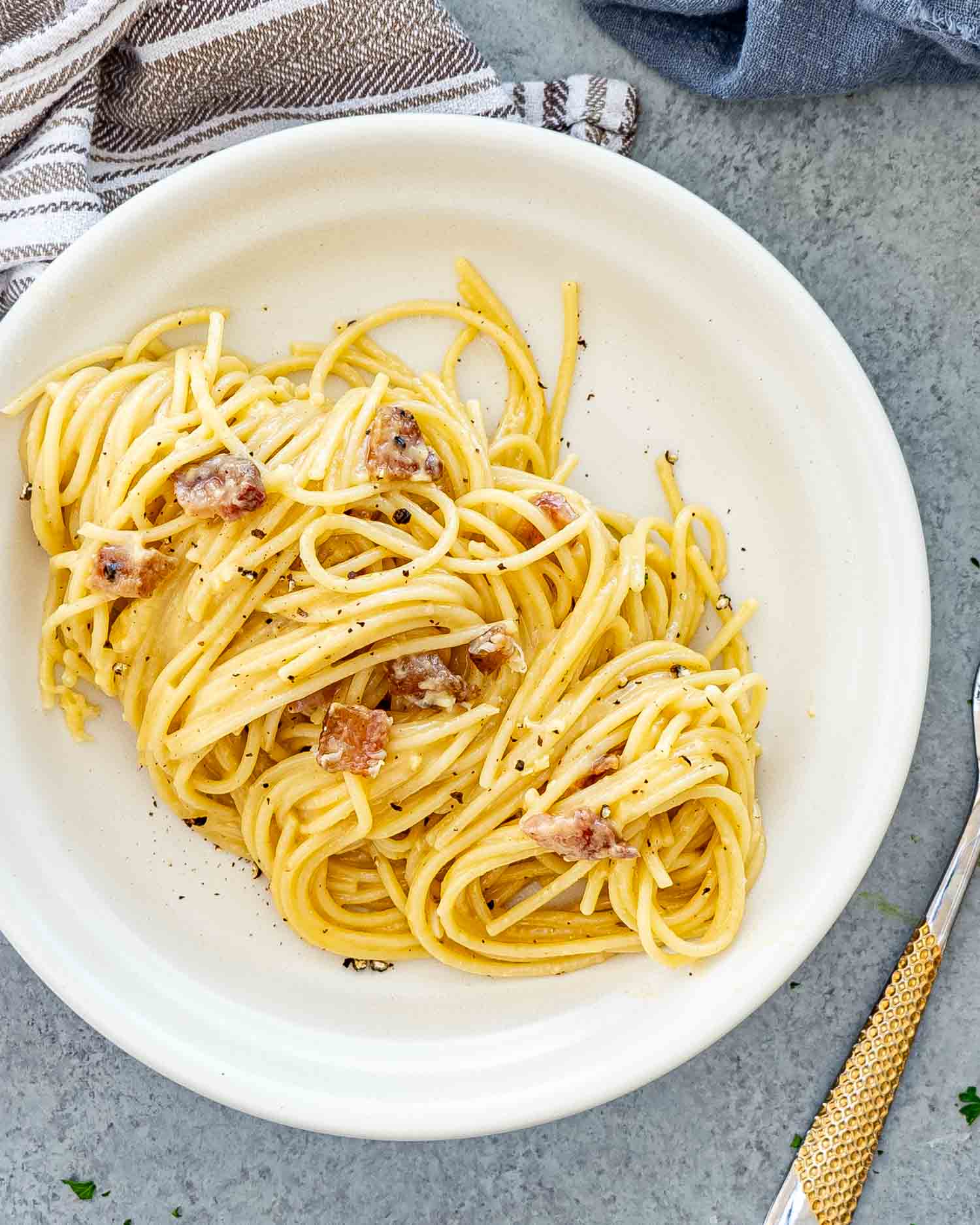 a serving of freshly made carbonara in a white plate.