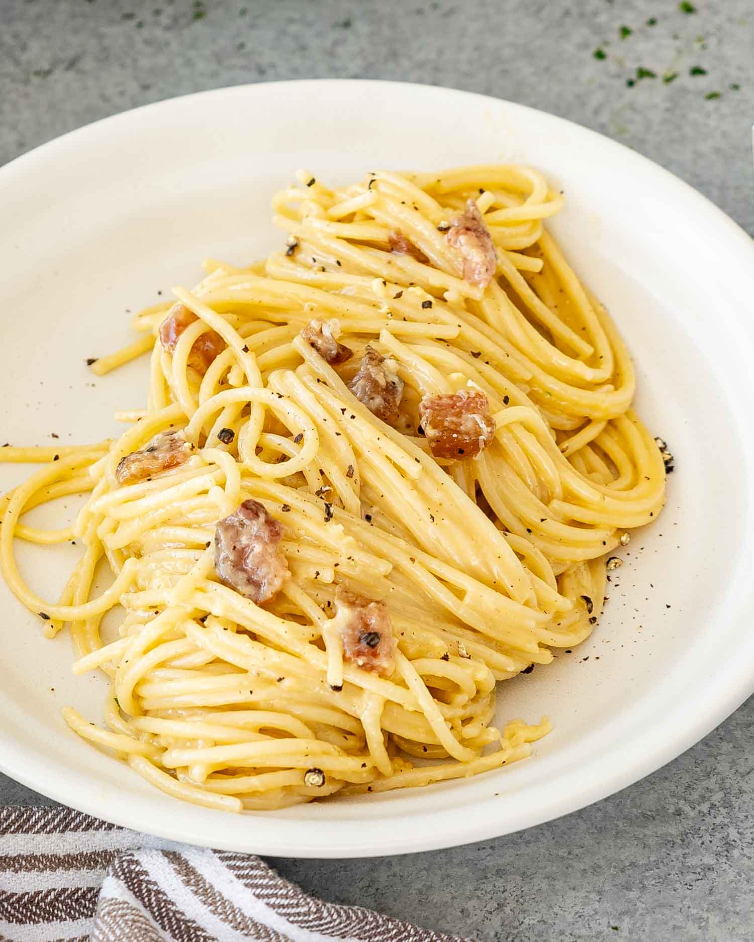 a serving of freshly made carbonara in a white plate.