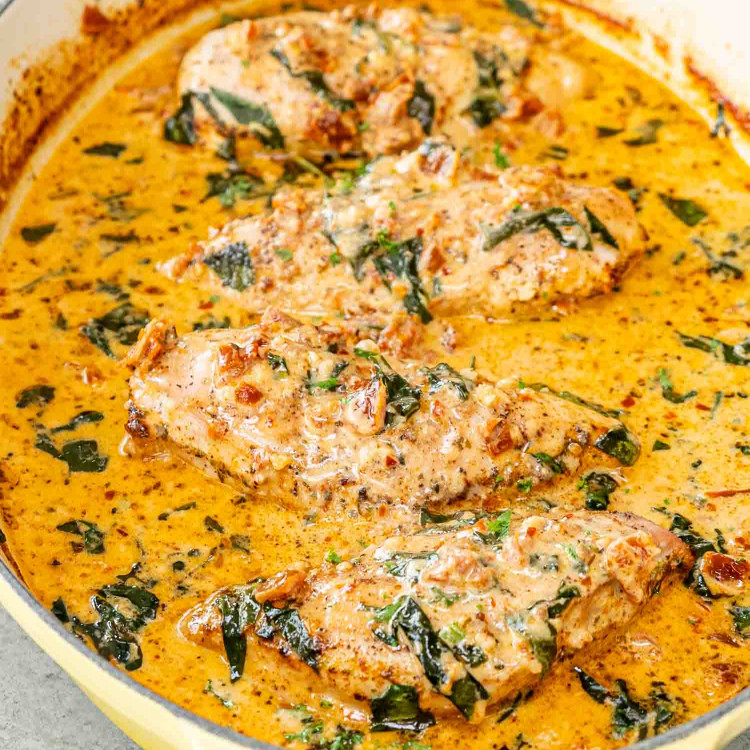 creamy baked chicken breasts in a oval cast iron pot.
