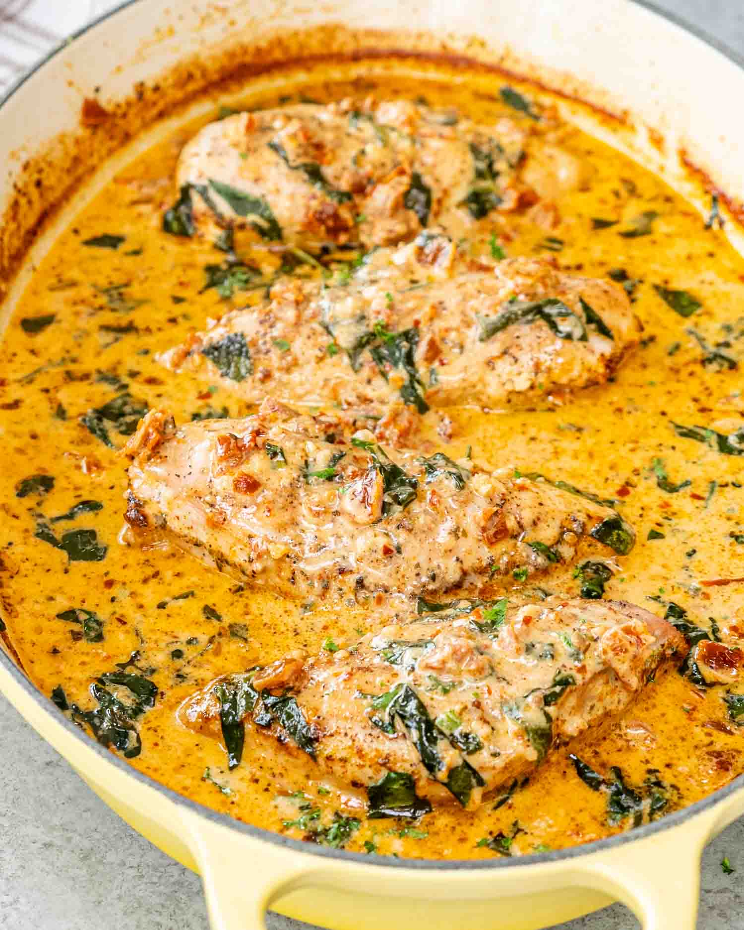 creamy baked chicken breasts in a oval cast iron pot.