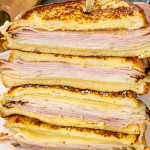 a monte cristo sandwich cut in half on a cutting board.