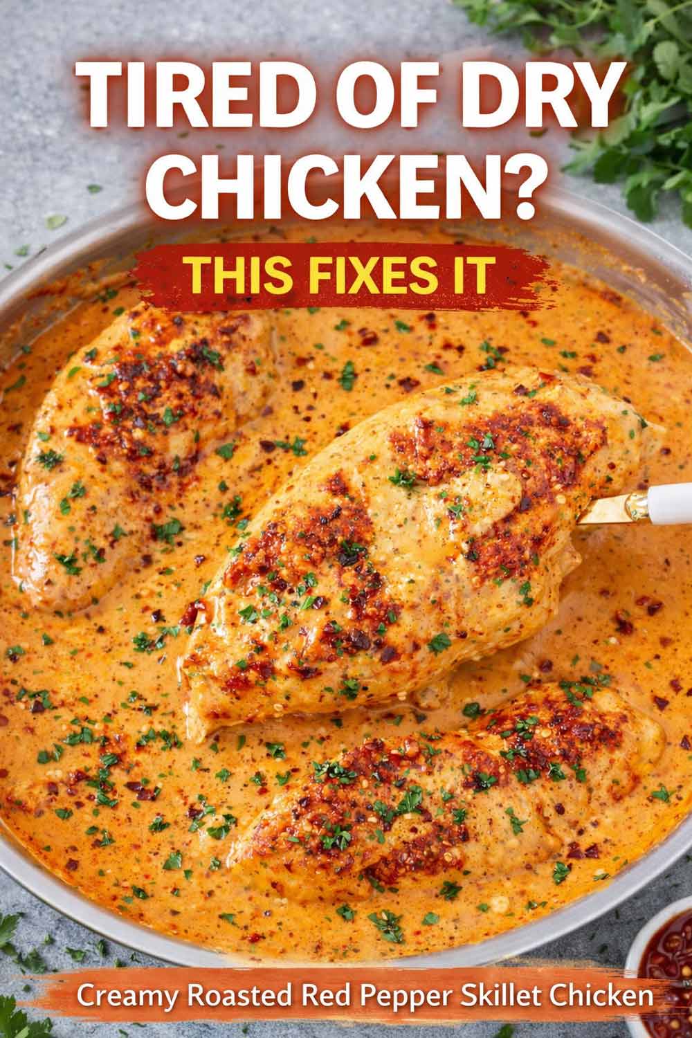 A close up shot of a large chicken breast being lifted from a skillet of creamy roasted red pepper sauce with a white handle server showing the thick velvety texture of the sauce and crispy bacon bits.