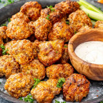 sausage balls in a metal plate along some ranch dressing.