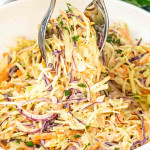 creamy homemade coleslaw with red cabbage and carrots in a white bowl/