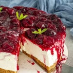 a no bake cheesecake topped with cherry pie filling on a platter.