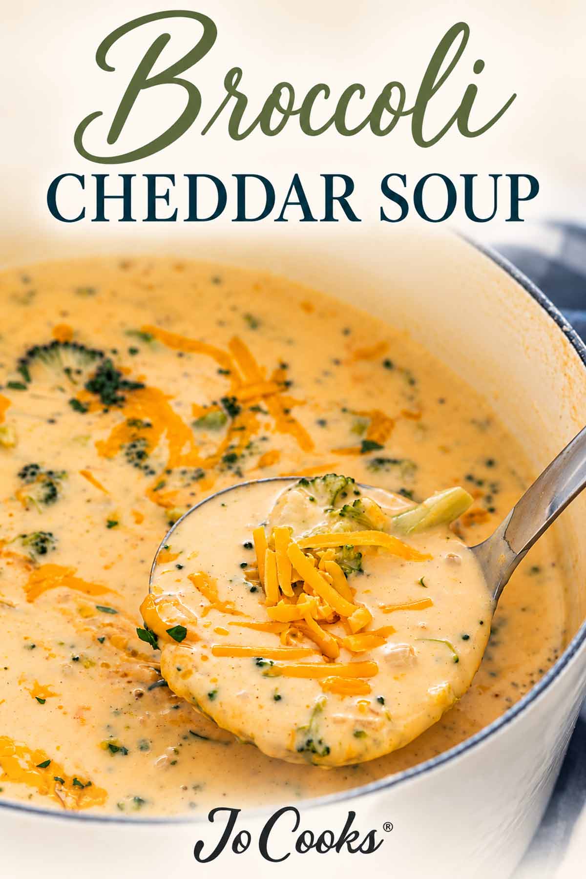 Ladle filled with broccoli cheddar soup and shredded cheese resting in a pot, with recipe title and Jo Cooks logo.