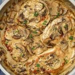 Overhead view of creamy Dijon mushroom pork chops cooked in a rich sauce with fresh herbs and mushrooms.