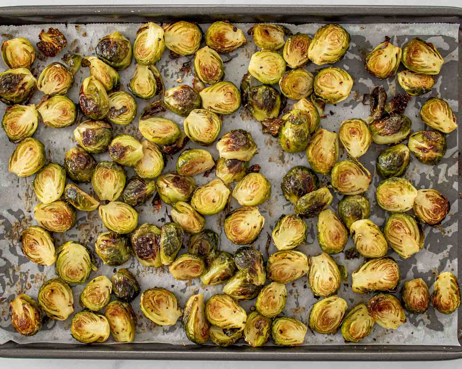 process shots showing how to make maple dijon roasted brussels sprouts.