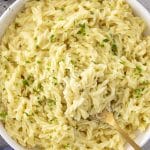 A big bowl of buttery cafeteria noodles made with egg noodles and cream of chicken, topped with fresh parsley.