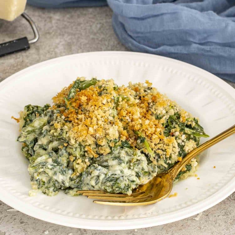 Creamed spinach gratin spooned onto a plate, showcasing creamy texture and golden breadcrumb crust for an easy side dish.