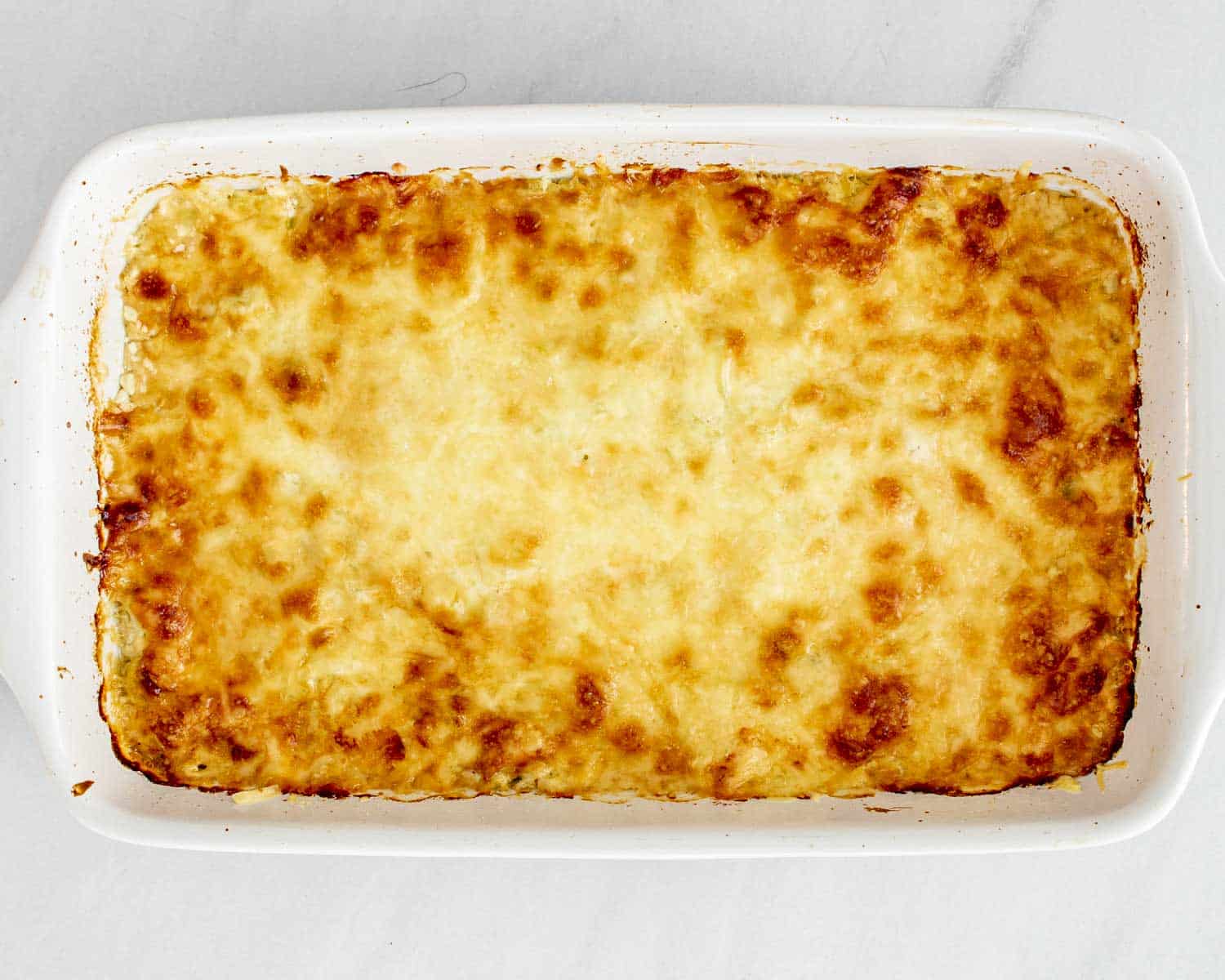 process shots showing how to make gruyere leeks scalloped potatoes.