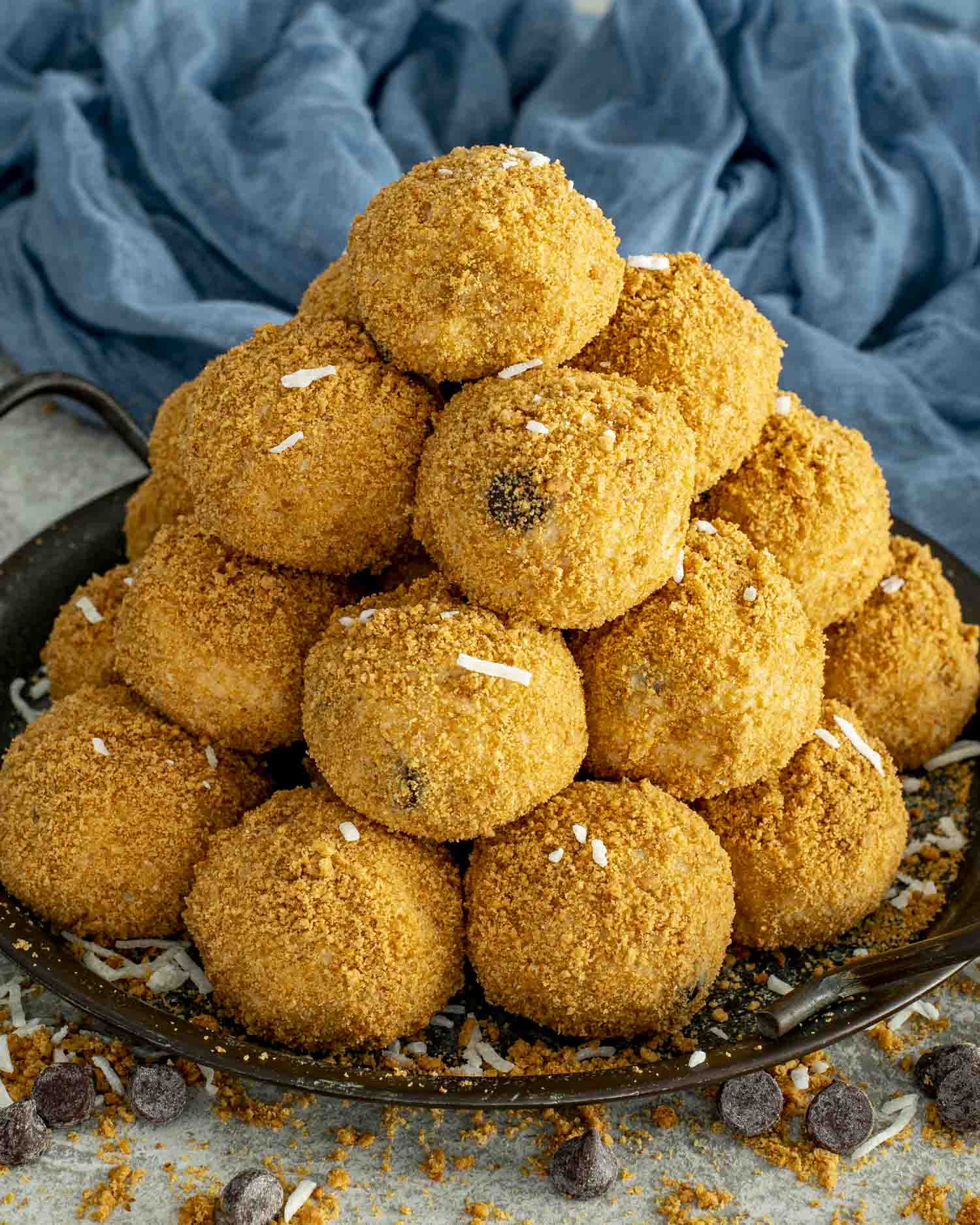 A tall pyramid of graham-coated Moose Farts on a round dark plate, highlighting their golden texture and coconut flecks.
