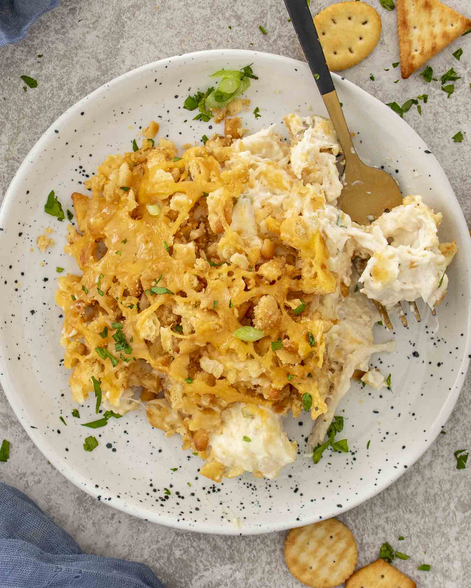 Creamy Neiman Marcus Chicken Casserole on a plate with golden Ritz cracker topping, tender chicken filling, and fresh parsley garnish.